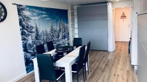 a dining room with a white table and chairs at Le Cocon étoilé in Métabief +6 photos
