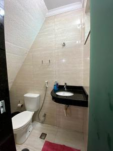 a bathroom with a toilet and a sink at Casa de lazer 3Y in Maringá
