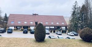 a large building with cars parked in a parking lot at Le Cocon étoilé in Métabief