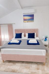 a bedroom with a large bed with blue pillows at Urban Gold Apartment in Mostar