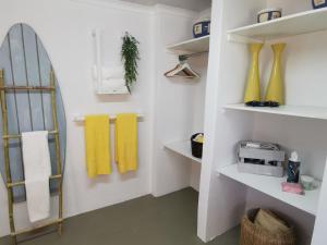a bathroom with white shelves and yellow towels at Iewers Rus in Strand +27 photos