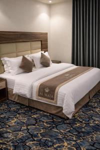 a bedroom with a large bed with white sheets and pillows at منــازل الماسة للشقق المخدومة in Unayzah +47 photos