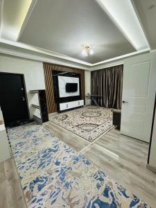 a large room with a television and a large rug at ЖК 2 Keruen Saray in Türkistan