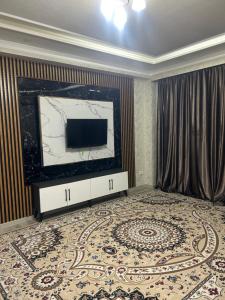 a living room with a television and a large rug at ЖК 2 Keruen Saray in Türkistan