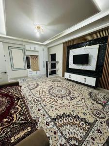 a large living room with a television and a large rug at ЖК 2 Keruen Saray in Türkistan