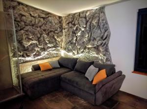 a couch in a room with a stone wall at Villa Green Relax in Gornji Mihaljevec