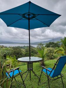 a table and two chairs with an umbrella at Villa Terraza in El Castillo de La Fortuna