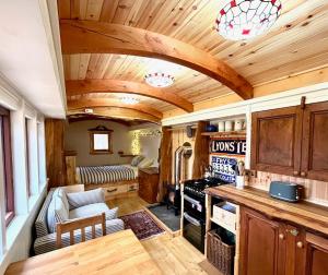 a kitchen with a living room with wooden ceilings at Mòr Braw in Banavie