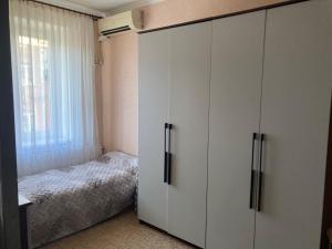a bedroom with white cabinets and a bed at Apartment Artynova 29,світло завжди in Vinnytsya