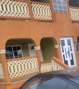 a building with a balcony and a car in front of it at DaRoyals in Junction