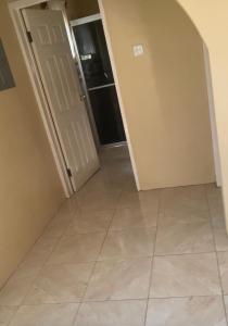 a hallway with a tile floor and an open door at DaRoyals in Junction