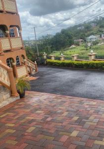 a building with a bench next to a brick driveway at DaRoyals in Junction