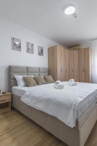 ein Schlafzimmer mit einem großen Bett mit weißer Bettwäsche in der Unterkunft Borca 3 in Borča