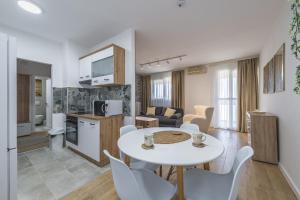 eine Küche und ein Wohnzimmer mit Tisch und Stühlen in der Unterkunft Borca 3 in Borča