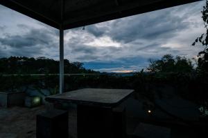 a table sitting under an umbrella under a cloudy sky at Heaven R in Kandy
