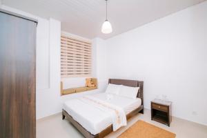 a white bedroom with a bed and a window at Heaven R in Kandy