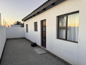 a white building with a door on the side of it at DECADE Self-catering in Swakopmund