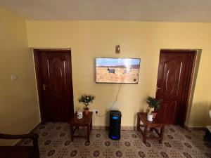 a room with two wooden doors and two tables at Golf B&B in Nyahururu