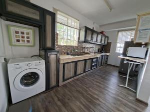 a kitchen with a washer and dryer in a room at Appartment Camellia in Flic-en-Flac