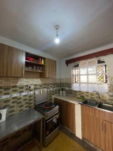 a kitchen with a stove and a sink at Golf B&B in Nyahururu