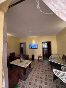 a living room with a table and a tv at Golf B&B in Nyahururu
