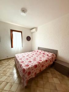 a bedroom with a bed with a red bedspread at Casa Franco in Lampedusa