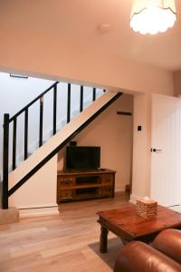 a living room with a staircase with a television at Britannia Lodge in Howden