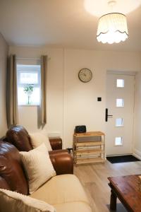 a living room with a couch and a clock on the wall at Britannia Lodge in Howden +59 photos