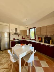 a kitchen with a white table and white chairs at Casa Franco in Lampedusa