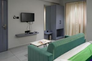 a living room with a couch and a tv at Comfort Inn Baner- Indian nationals only in Pune +23 photos