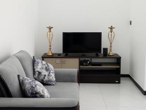 a living room with a couch and a flat screen tv at Nimsara Homes in Veyangoda