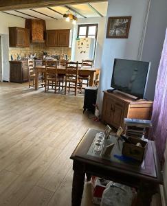 a living room with a tv and a dining room at Poitevins in Saint-Astier