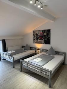 a room with two beds and a picture on the wall at Hotel Rühen, 24 Stunden Check in, Küche, kostenfreie Parkplätze in Rühen
