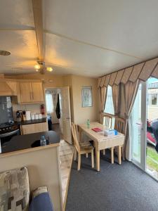 a kitchen and a living room with a table and chairs at seton sands caravan in Port Seton +12 photos