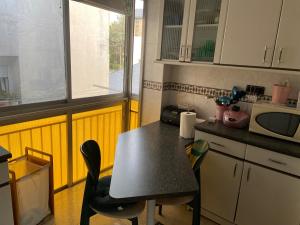 a kitchen with a table and chairs and a microwave at Refugio de ensueño in Sabiñánigo