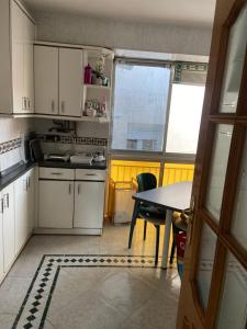 a small kitchen with white cabinets and a table at Refugio de ensueño in Sabiñánigo