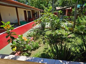 a garden with flowers and plants in front of a house at peixes apart in Puerto Iguazú +32 photos