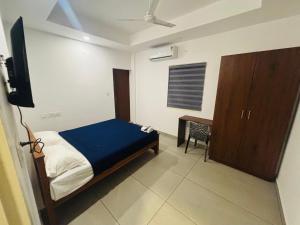 a bedroom with a bed and a television in it at Mansori Residency in Cochin +7 photos