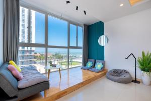 a living room with a couch and a large window at Kozy Home Apartment in Vung Tau - Tam Thang Tower View & Back Beach step away in Vung Tau