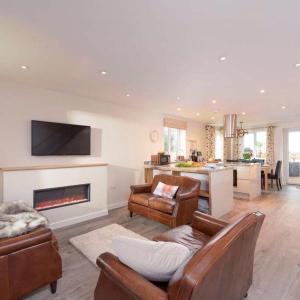 a living room with a fireplace and a kitchen at The Woodland Collection, 10 mins from beaches in Hayle