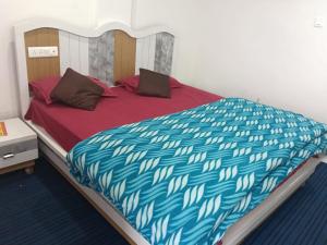 a large bed with a blue and white comforter at Lekhwar in Chamba