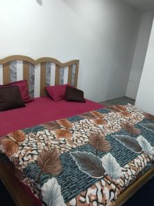 a bed with a colorful comforter on top of it at Lekhwar in Chamba