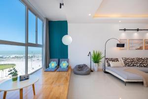 a bedroom with a bed and a table and a view of the beach at Kozy Home Apartment in Vung Tau - Tam Thang Tower View & Back Beach step away in Vung Tau