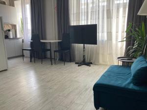 a living room with a couch and a tv and a table at Apartment Artynova 29,світло завжди in Vinnytsya