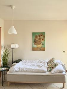 a bed in a room with a painting on the wall at Casa Diana - Panoramablick auf den Gardasee in Pieve +11 photos