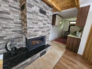 a fireplace in a living room with a stone wall at Villa Fresku in Peje