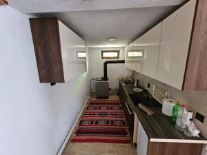 a hallway with a kitchen with a rug on the floor at Villa Fresku in Peje +14 photos