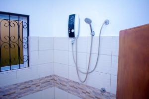 a bathroom with a shower with a phone on the wall at Eunia homes in Kibarani