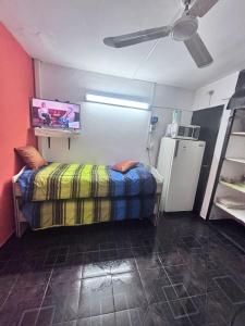 a room with a bed and a refrigerator at Guiñazú in Rodríguez Peña