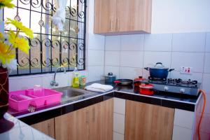 a kitchen with a sink and a stove at Eunia homes in Kibarani +7 photos